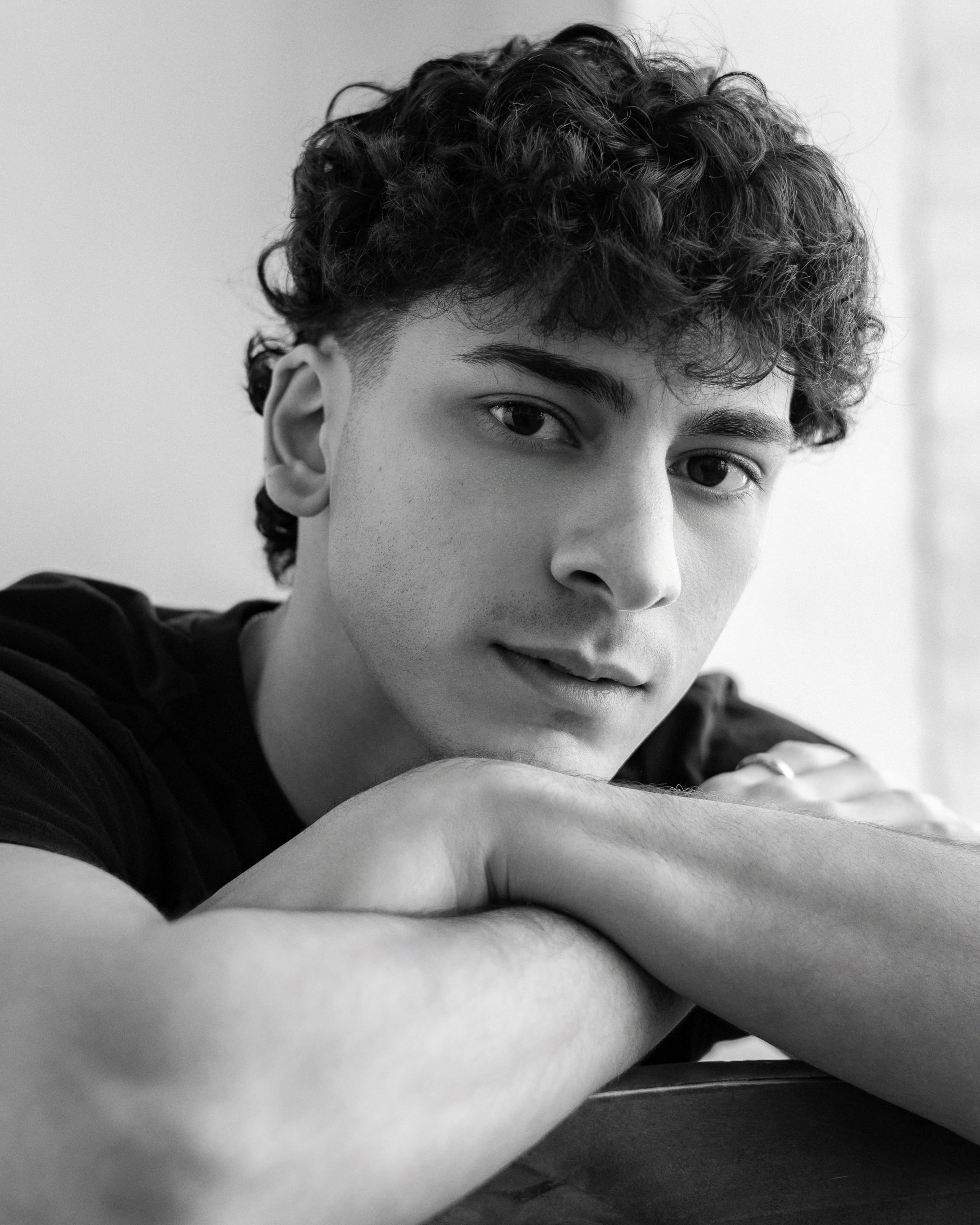 Black and white portrait of Adam resting on his arms