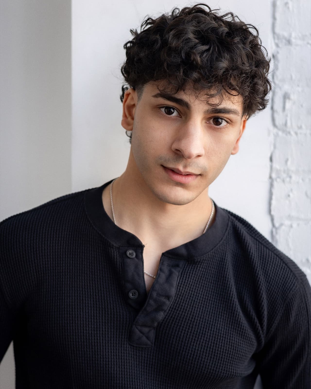 Adam Nimer in a black henley, photographed in natural light